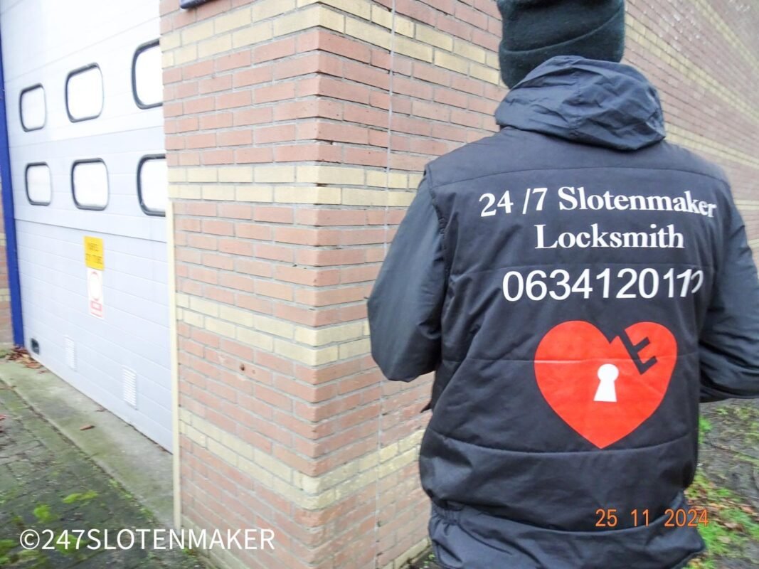 Slotenmaker in donkere jas bezig bij voordeur van woning in Amsterdam, met nadruk op professionele aanpak voor kerntrekbeveiliging