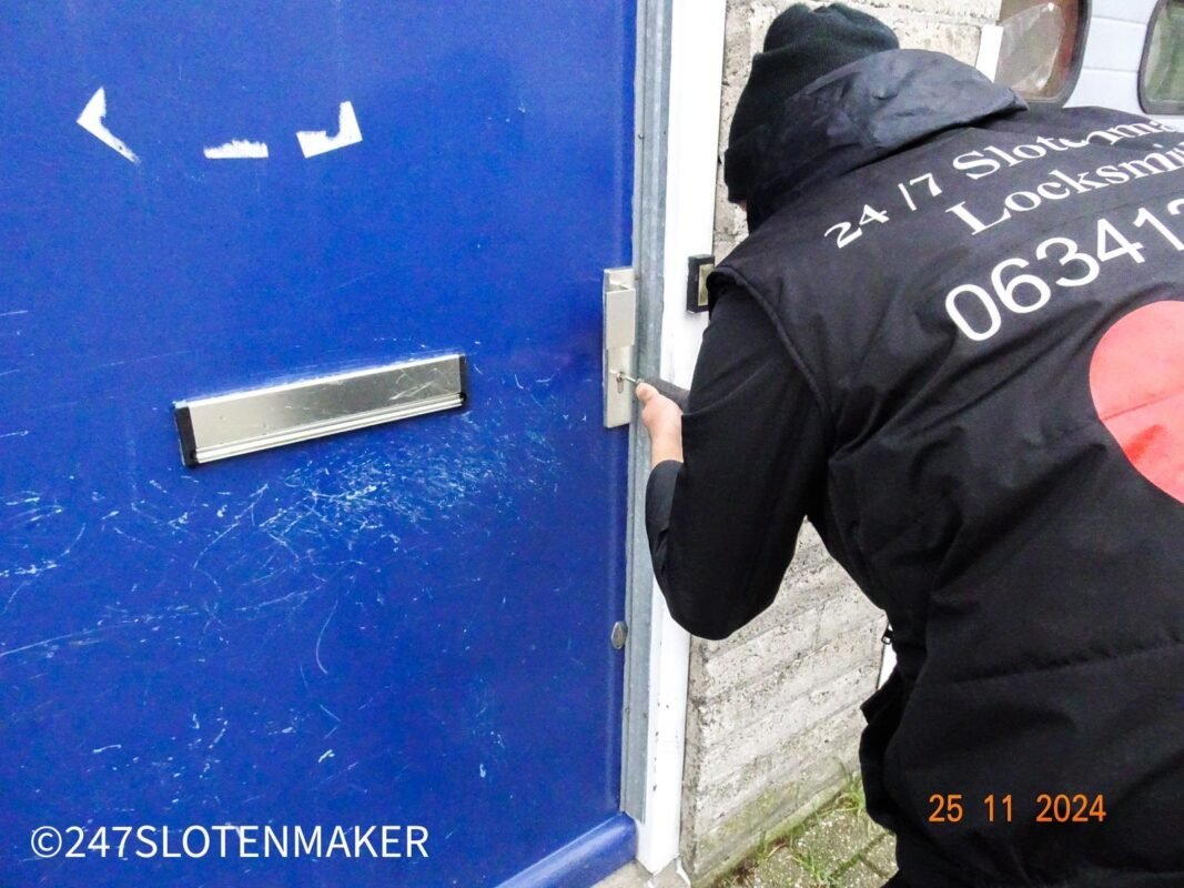 Slotenmaker opent voordeur van blauwe deur met speciaal gereedschap