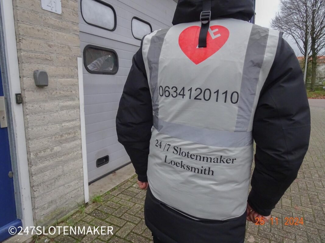 Slotenmaker in werkjas bij voordeur tijdens inspectie of beveiligingsklus